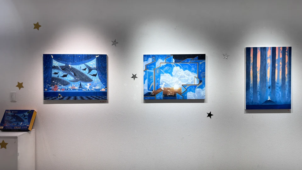 彼此之あいだ展：青い絵画3点と星の飾りが並ぶ展示壁