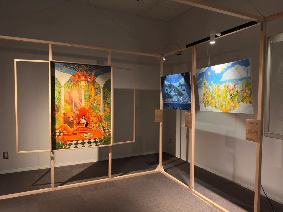 Id Rhapsody within a wooden window frame, alongside other works